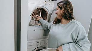 Vrouw haalt kleding uit de wasmachine