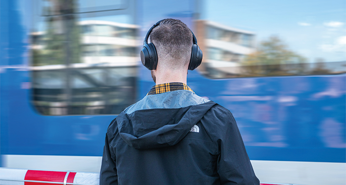 Muziek luisteren met koptelefoon wachtend voor de trein