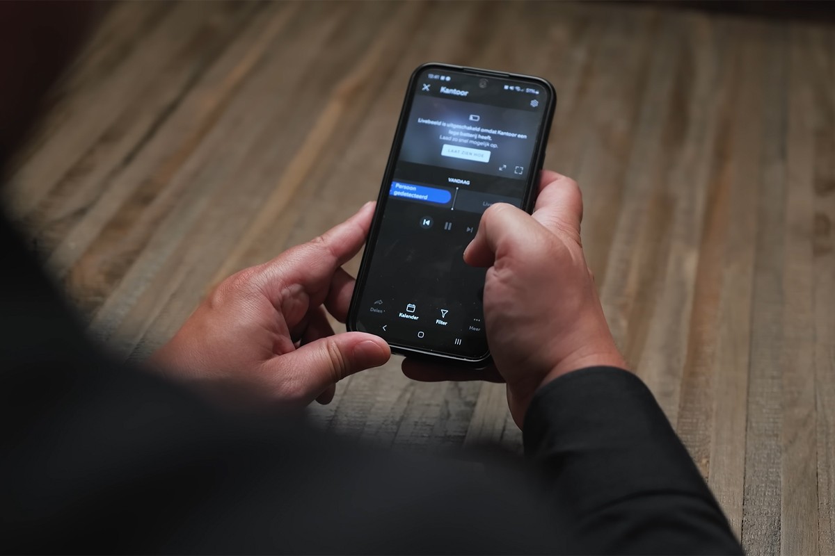 Ring app Persoon bedient videodeurbel vanuit de app op zijn telefoon
