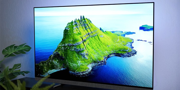 Philips OLED+ tv waarop een haarscherp groen eiland wordt weergegeven met opvallende rotspartijen dat omgeven is door helderblauw water