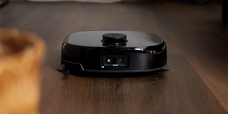 De Eufy Omni E28 rijdt over een donker houten vloer. Aan de voorzijde is een dubbele camera zichtbaar
