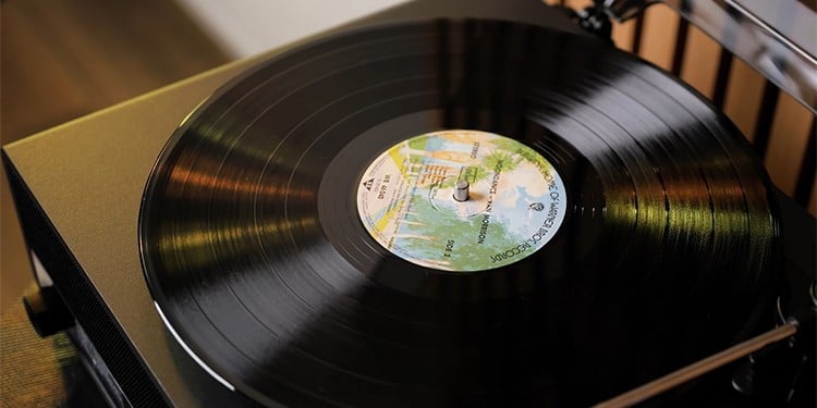 Close-up van een zwarte vinylplaat die draait op de Philips The Stevie, waarbij het middenlabel met kleurrijke opdruk goed zichtbaar is en de toonarm net boven de rand van de plaat hangt.