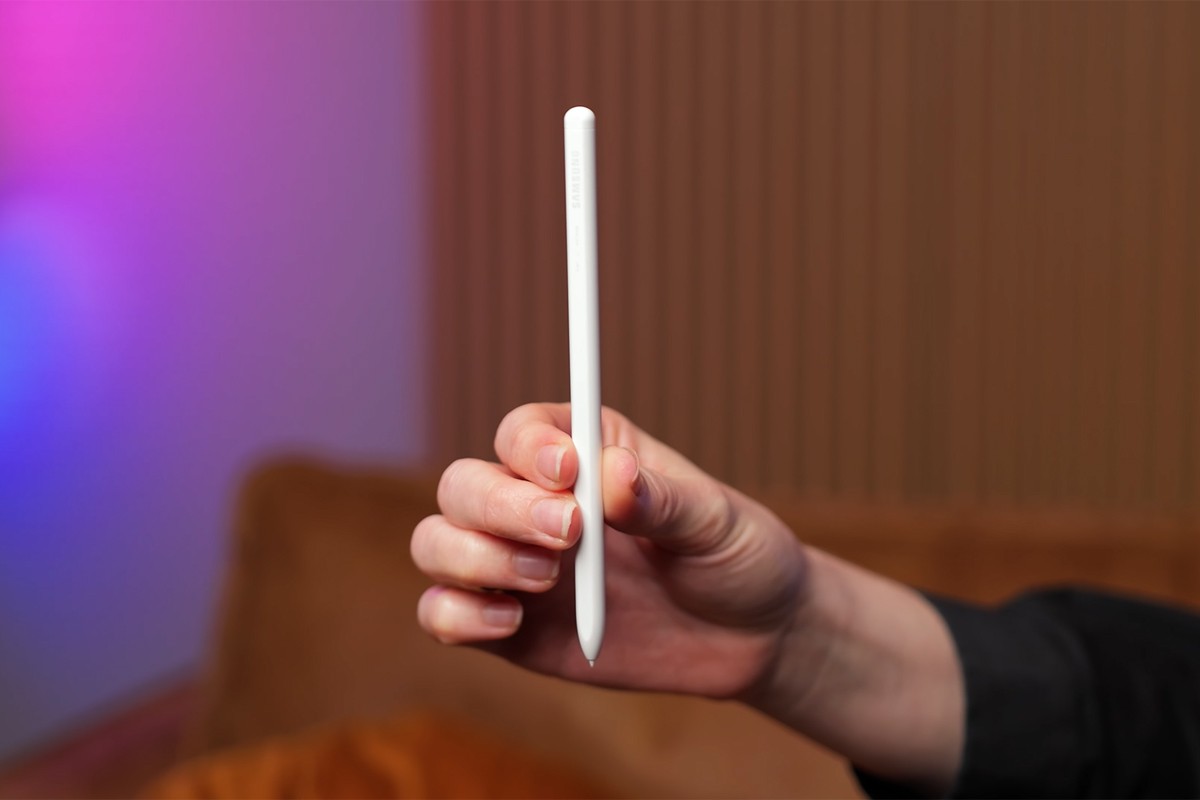 Close-up van een hand die een witte Samsung S Pen verticaal omhoog houdt, met de merknaam subtiel zichtbaar;