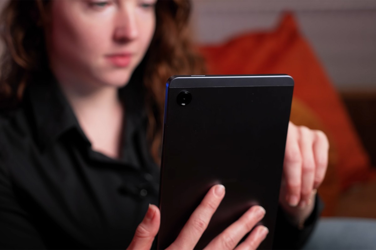 Vrouw houdt de Samsung Galaxy Tab A11-tablet vast en navigeert met haar rechterhand, terwijl de achterkant van de tablet met de enkele achtercamera zichtbaar is.