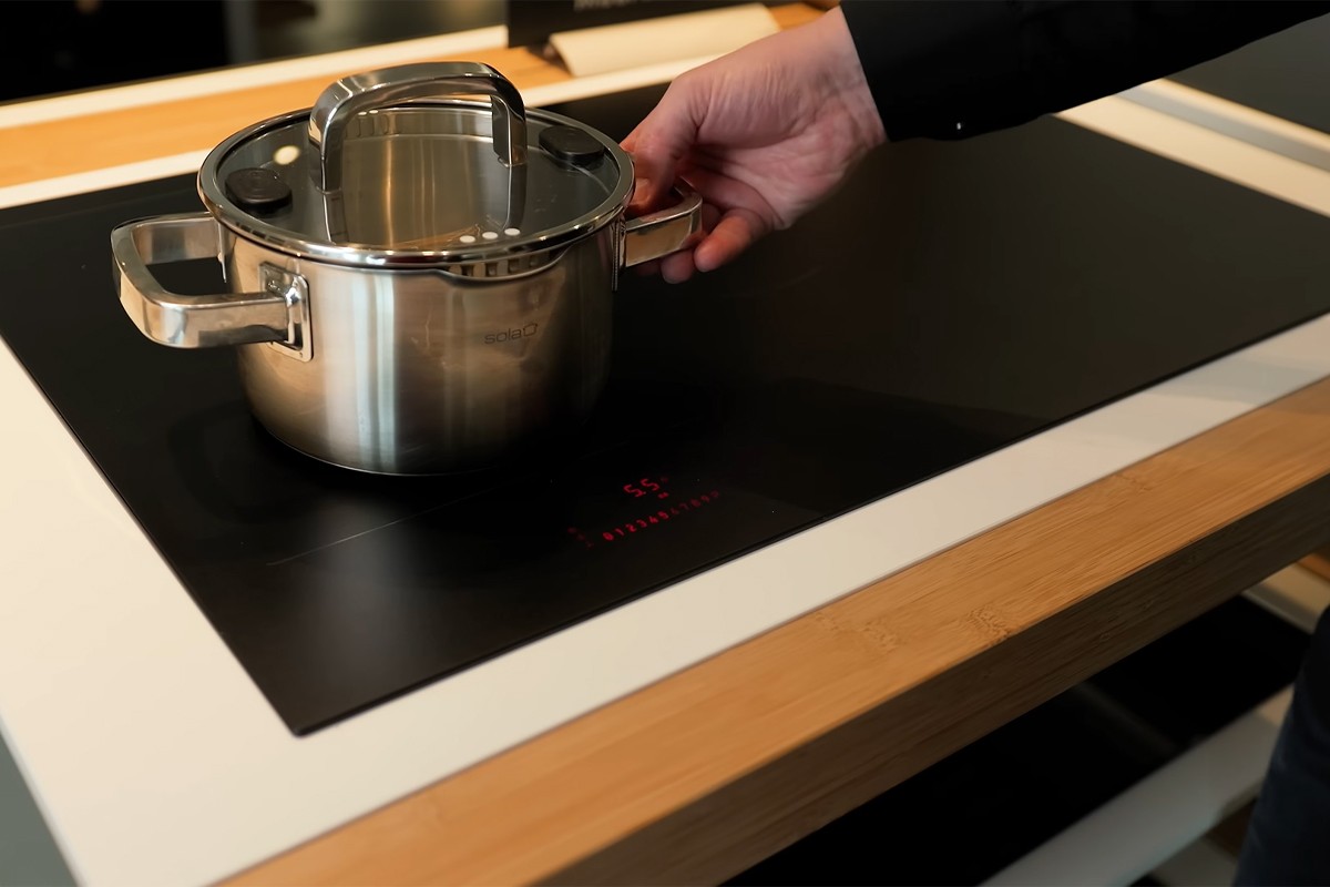 Persoon opent de Atag Serie 6 inbouwoven kijkt naar binnen.