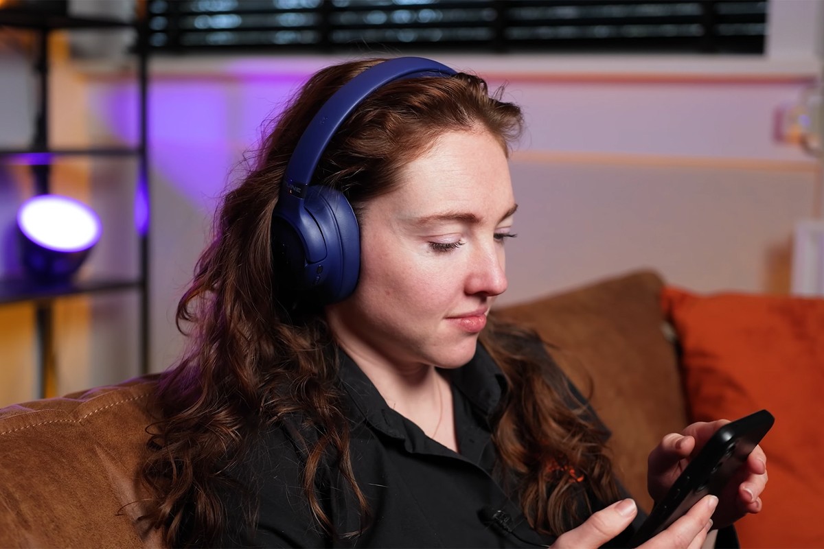 Persoon op de bank met paarse JBL Tune 780NC op haar hoofd