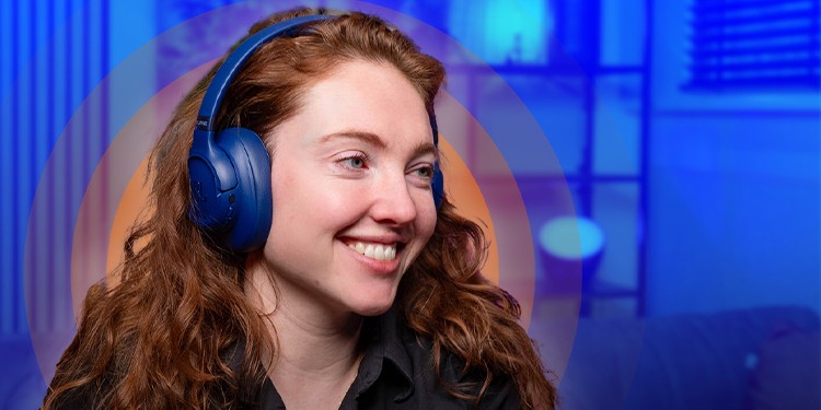 Persoon kijkt schuin waardoor de blauwe JBL Tune 780NC op haar hoofd goed zichtbaar is