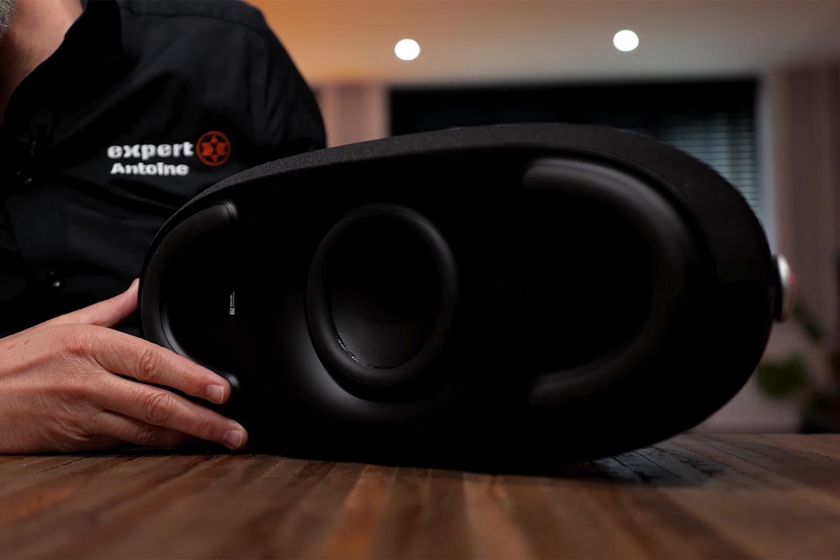 Persoon laat de onderkant van de Harman Kardon Go Play 3 zien waarbij de subwoofers te zien zijn.