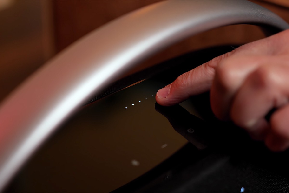Close-up van de Harman Kardon Go Play 3 waarbij de acculampjes te zien zijn die worden aangewezen door een vinger.