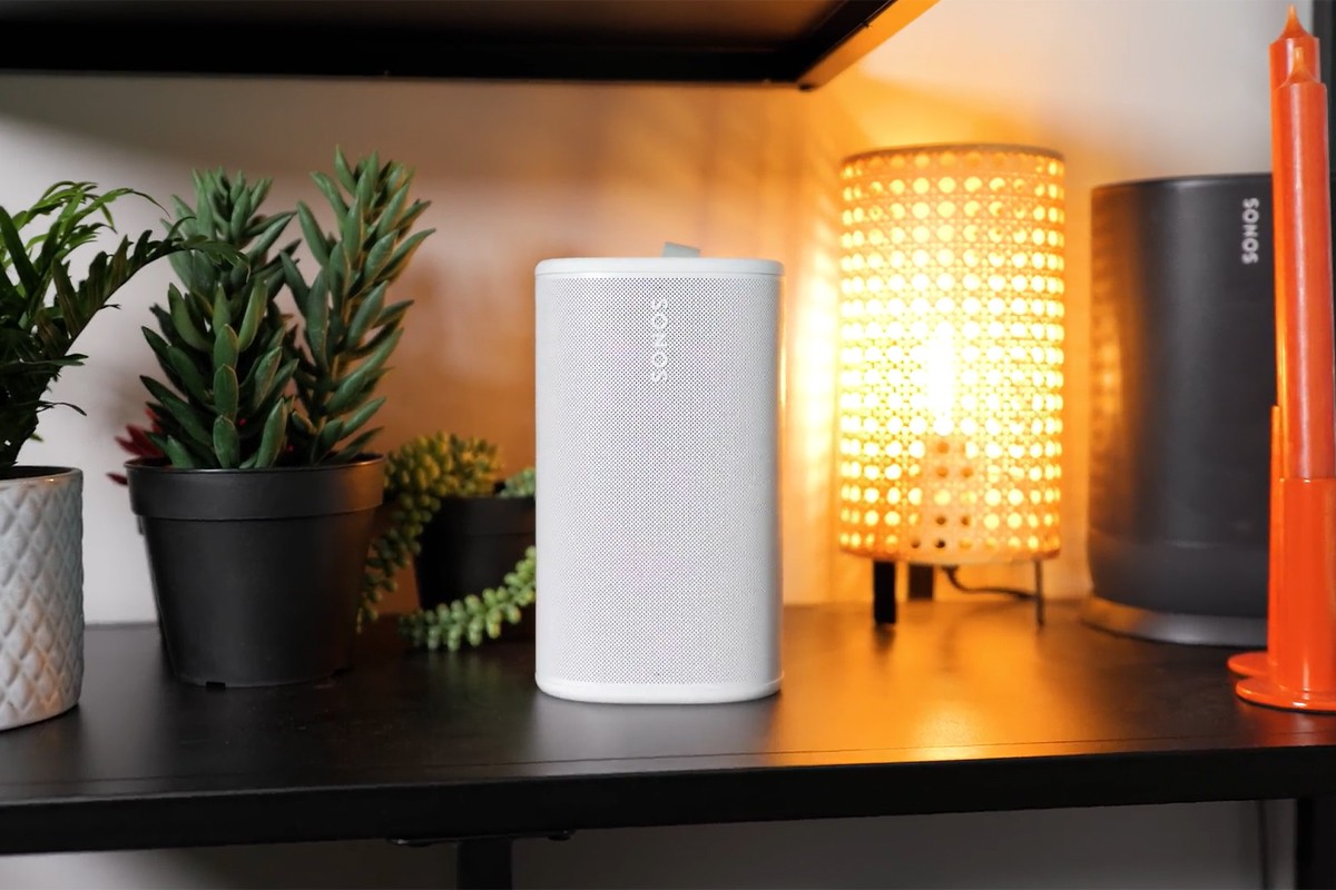 Sonos Play in de witte uitvoering staat in een zwarte kast met planten, een lamp en de Sonos Era 100.