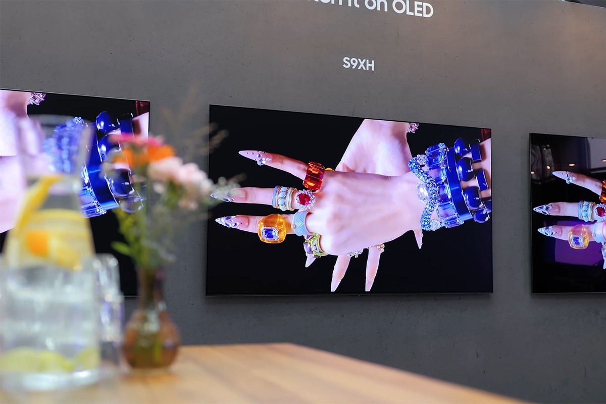 De Samsung S93H hangend aan de muur met op de voorgrond, onscherp, bloemen in een vaas.