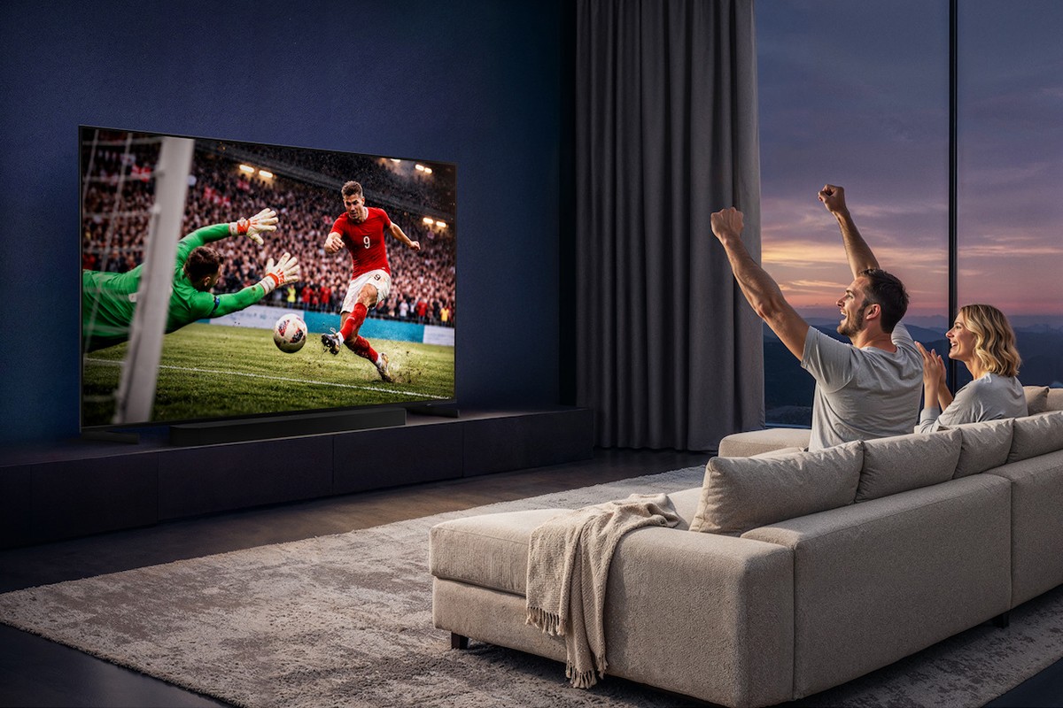 Samsung uiting van de Samsung R86H waarbij een man en een vrouw op de bank zitten in hun appartement en juichen om een doelpunt in een voetbalwedstrijd die is te zien op tv.