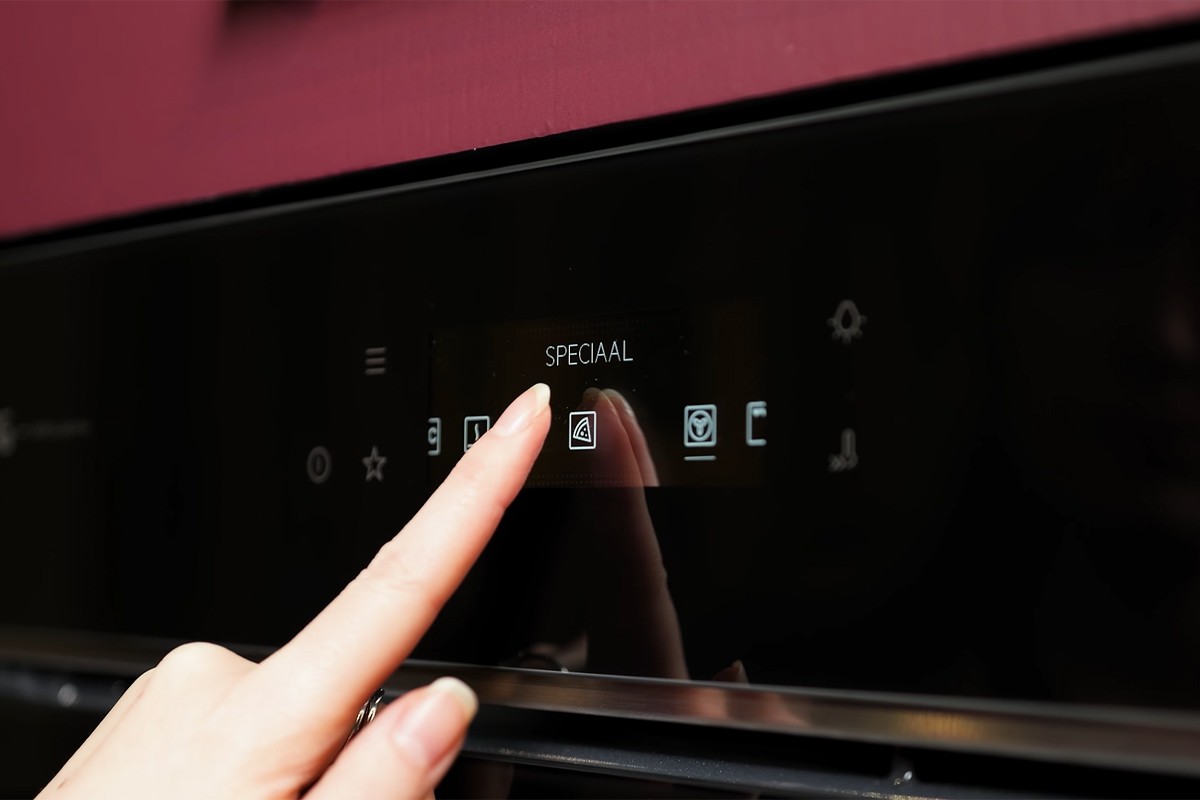 Vinger bedient het touchdisplay van de AEG 7000-serie inbouwoven.