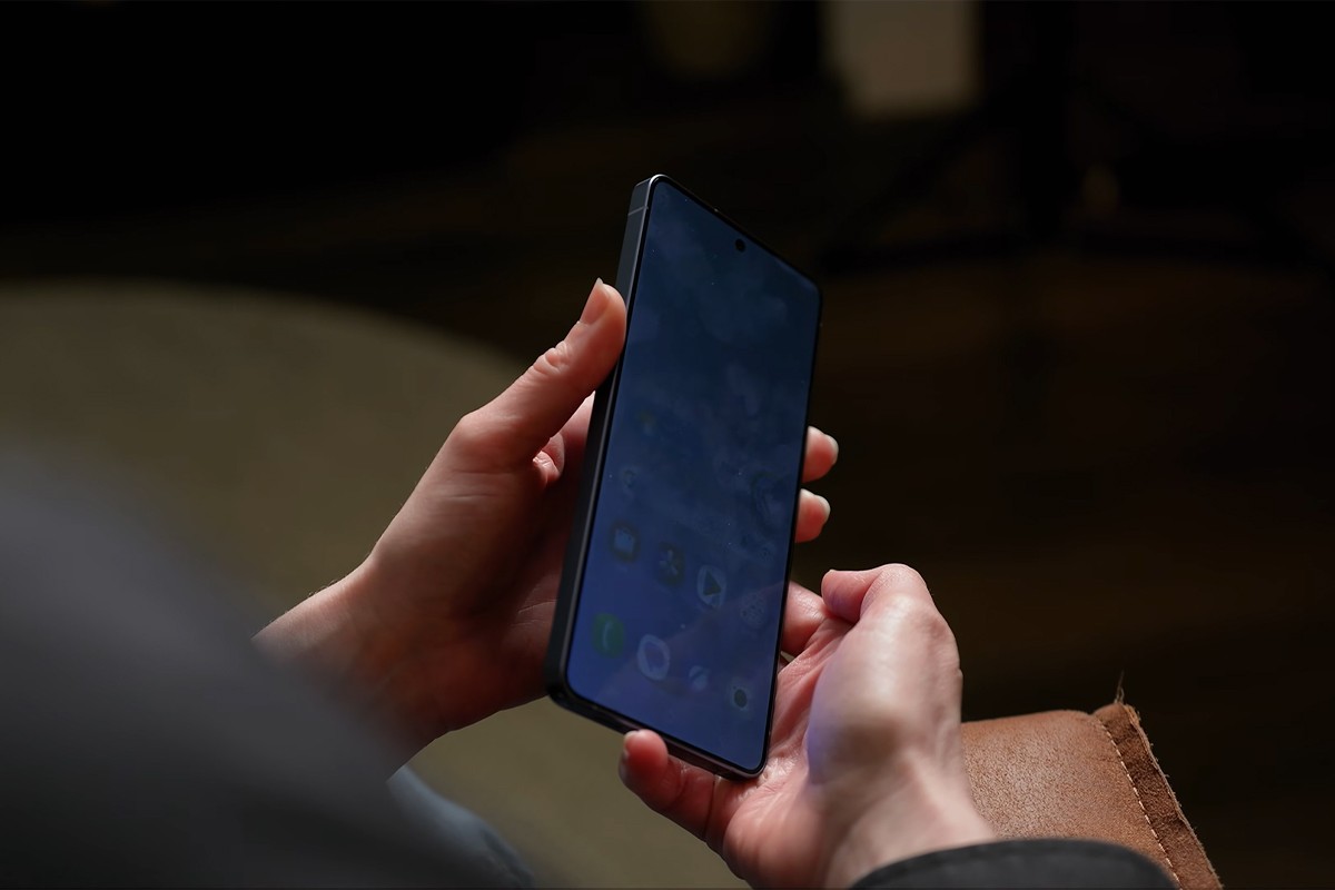 Persoon kantelt de Samsung Galaxy S26 Ultra waardoor het scherm gedimd wordt.