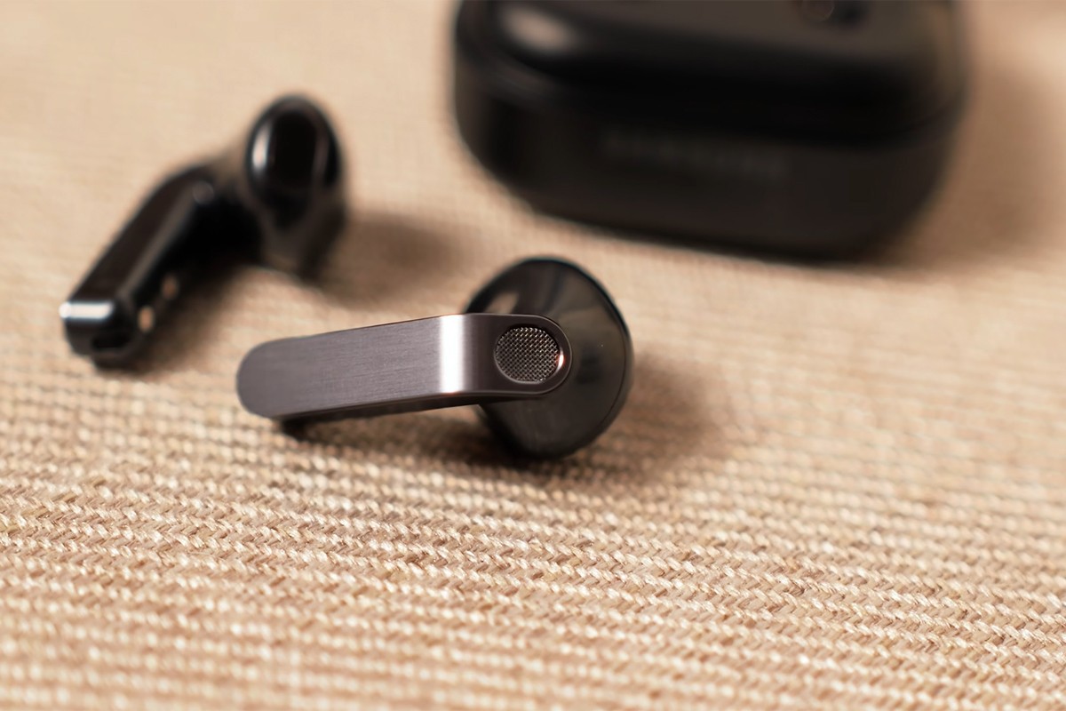 Close-up van de Samsung Galaxy Buds 4 die buiten het doosje op een stoffen ondergrond liggen.