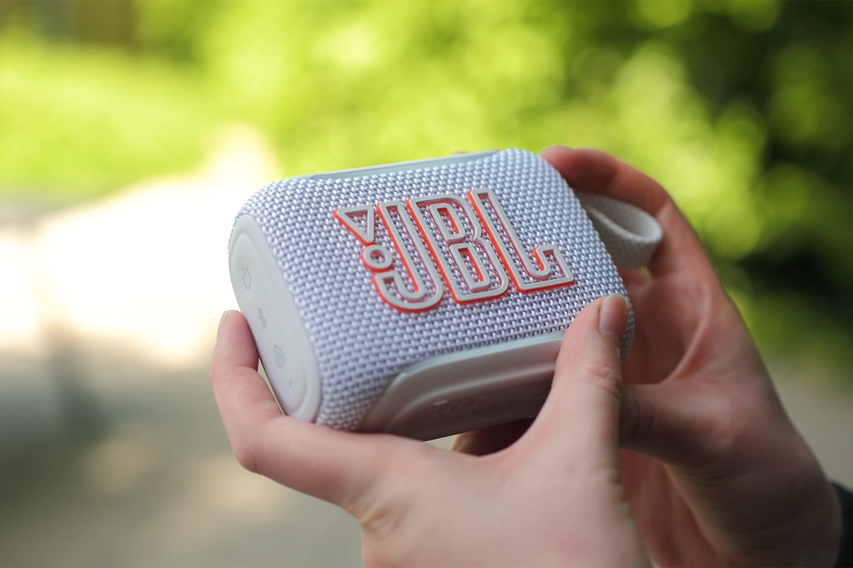 JBL GO 5 vastgehouden door een persoon in de buitenlucht.