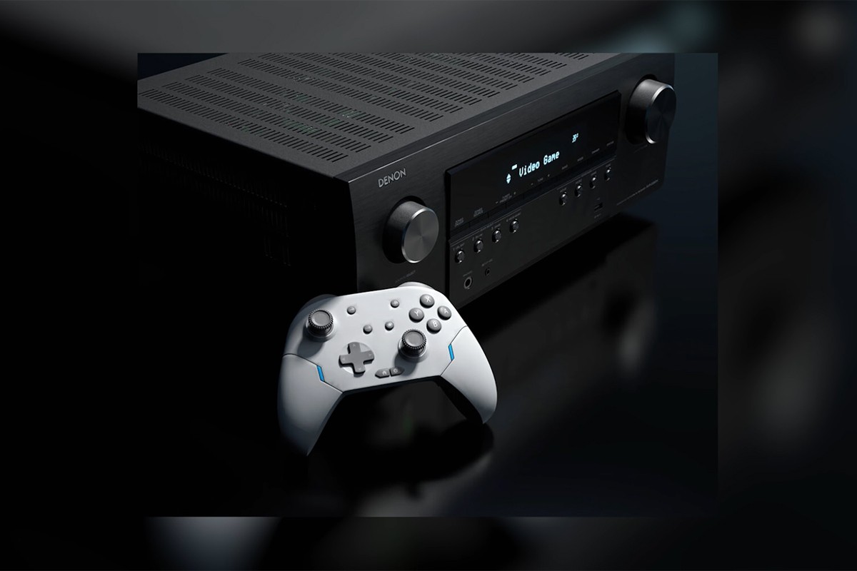 Witte gamecontroller ligt tegen de Denon AVR-receiver aan.